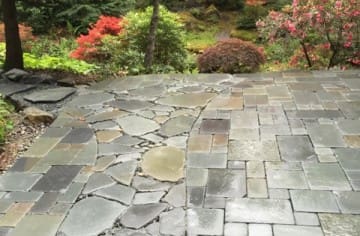 A Tumbled Blue Stone pathway meanders through a Tumbled Blue Stone patio hardscape